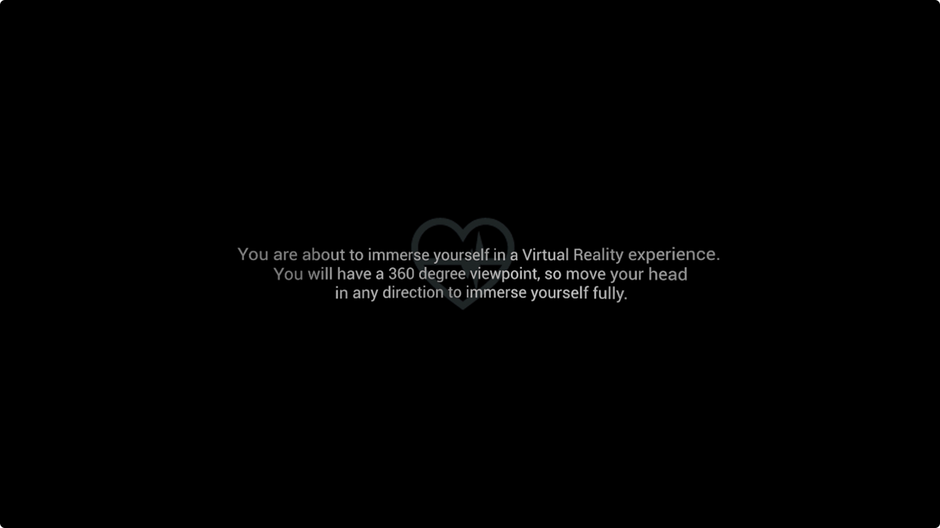 A black screen with the outline of a small, grey heart symbol in the middle, with text overlaying it that explains the user is about to enter a VR experience.