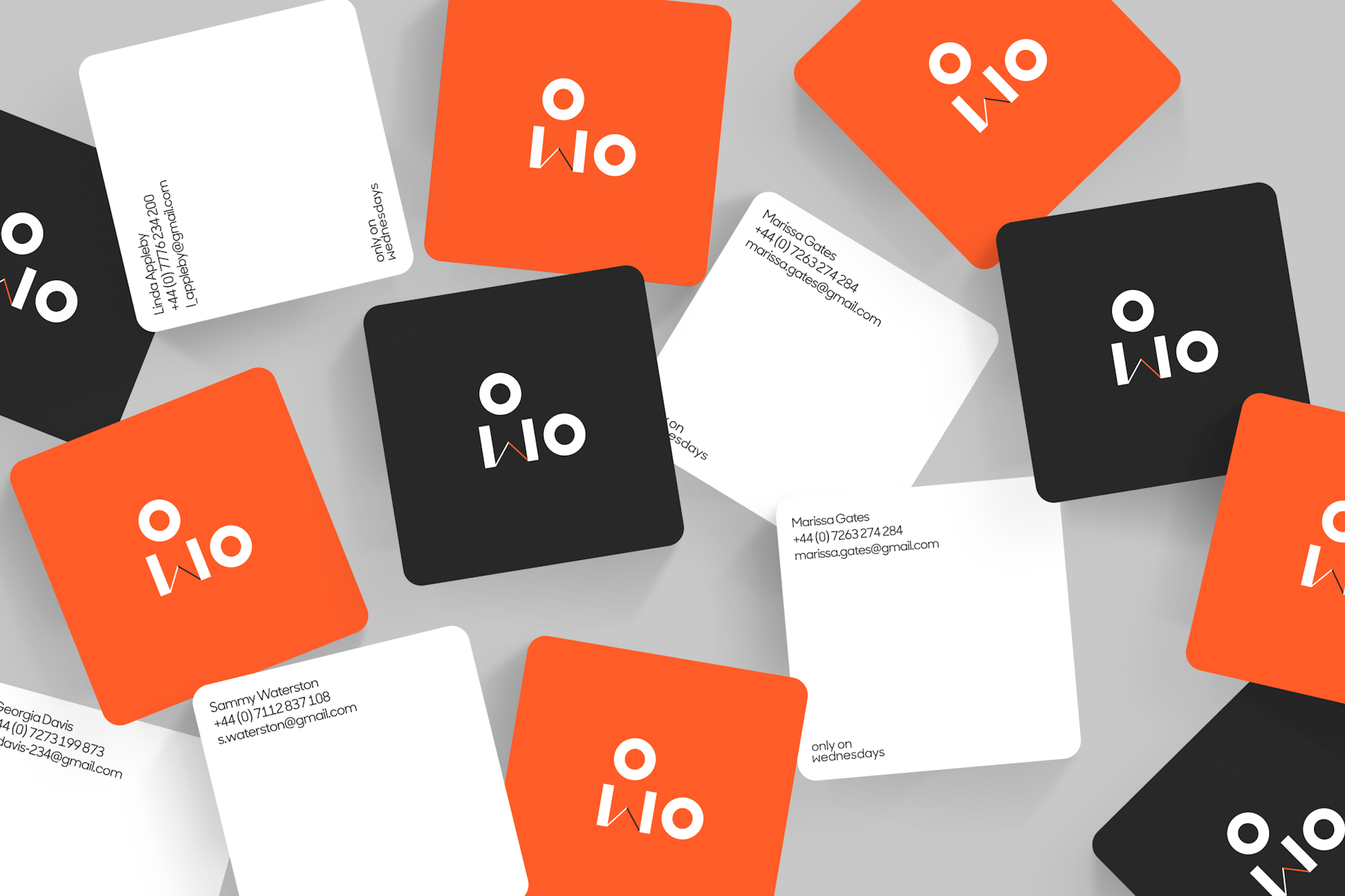 Only on Wednesdays branded business cards in black, white and orange arranged on a table
