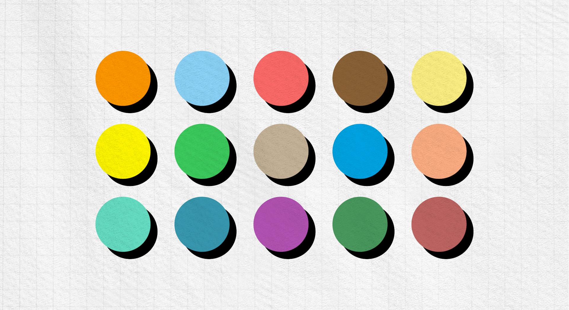 A wide range of colours is displayed in three rows of five columns, each dot has a drop shadow behind it.