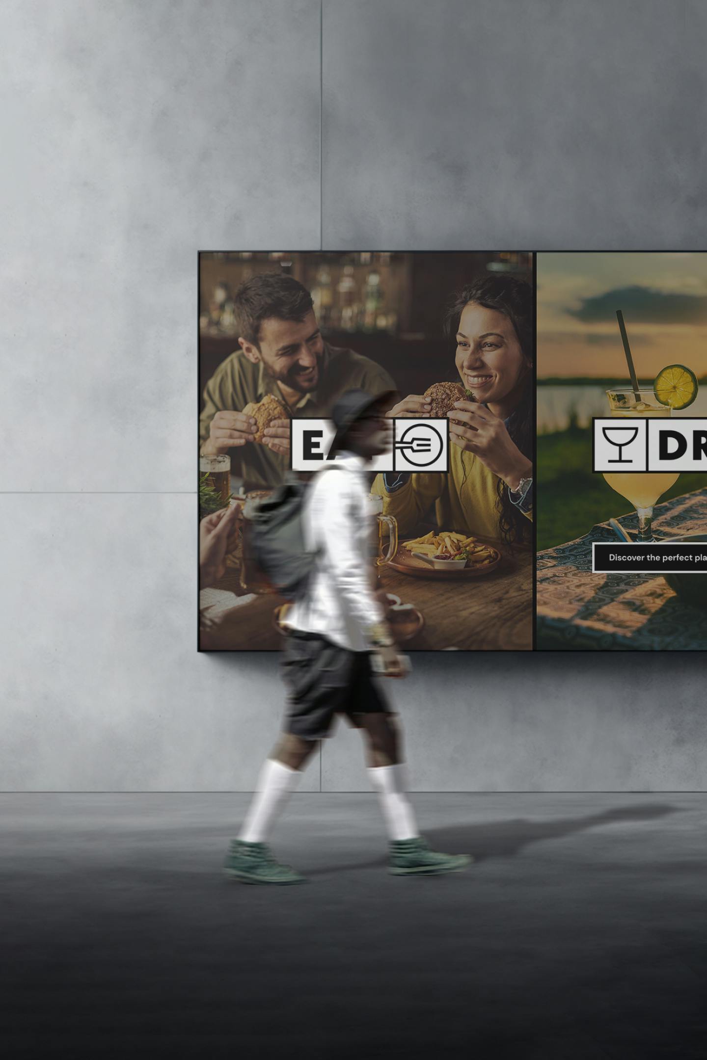 Image of a man walking past a billboard with a poster of Eat Drink Meet inside