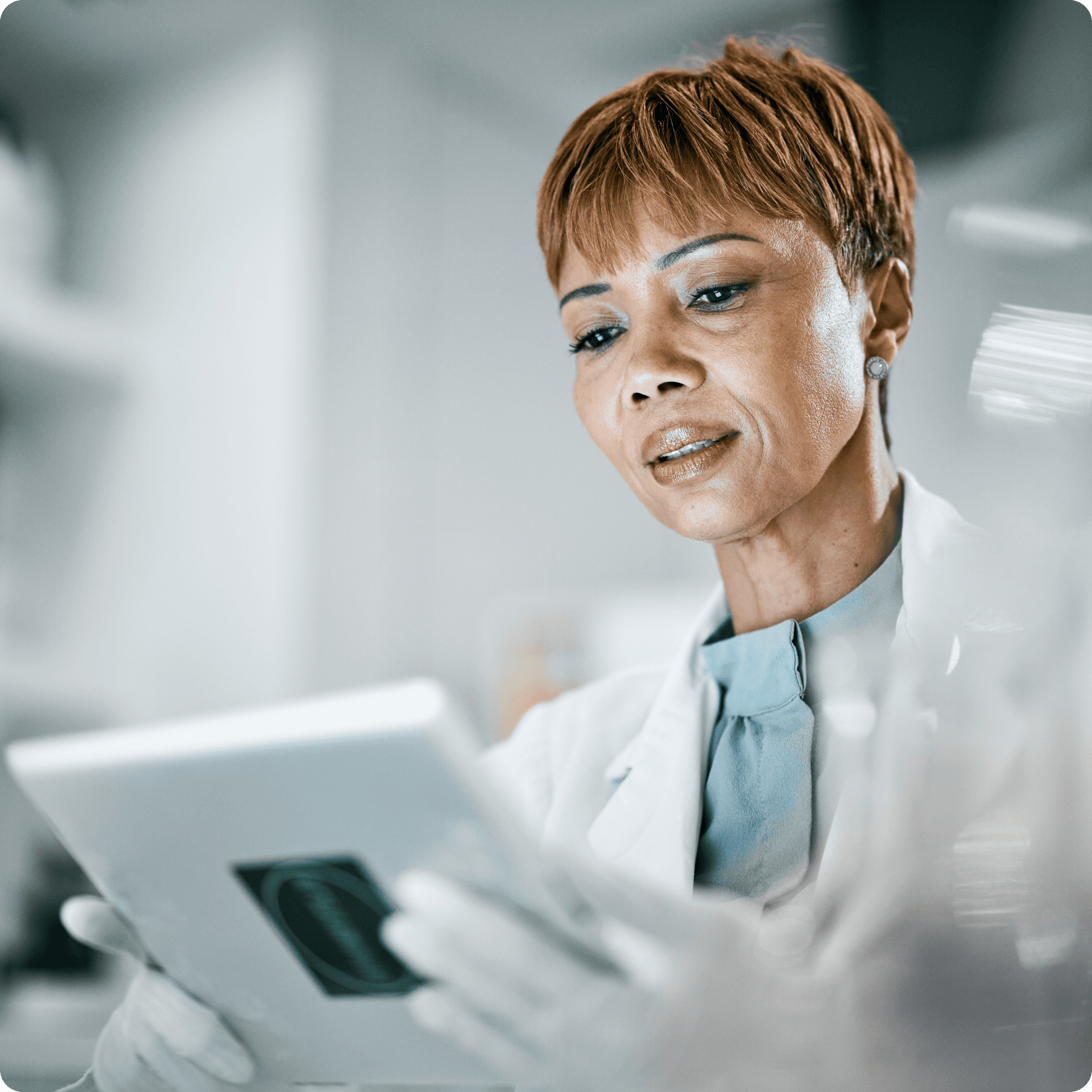 A medical professional is shown looking at a tablet screen, her expression is impartial.