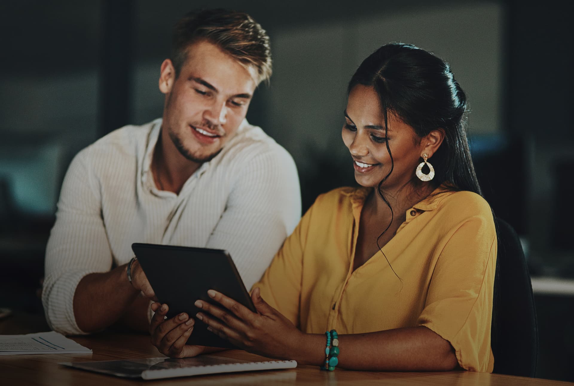 A couple using a tablet over a table.