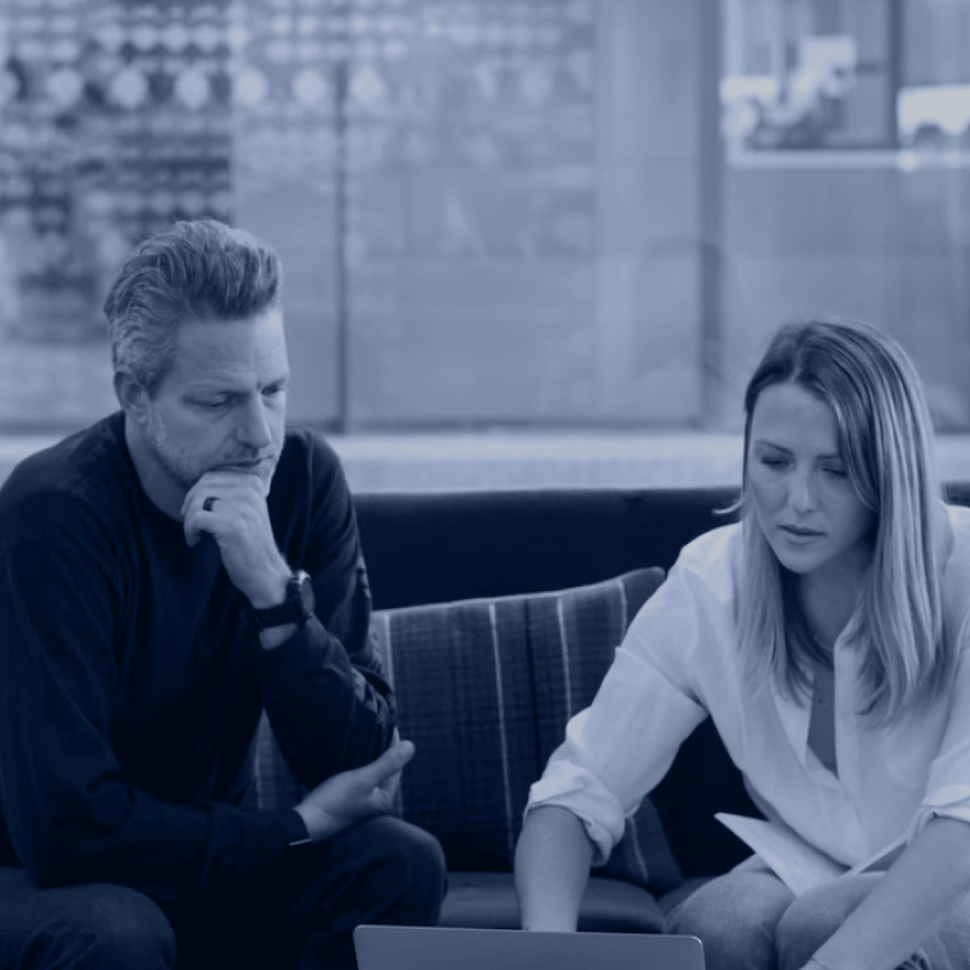 A man and woman sit on a sofa both looking at a laptop A man and woman sit on a sofa both looking at a laptop