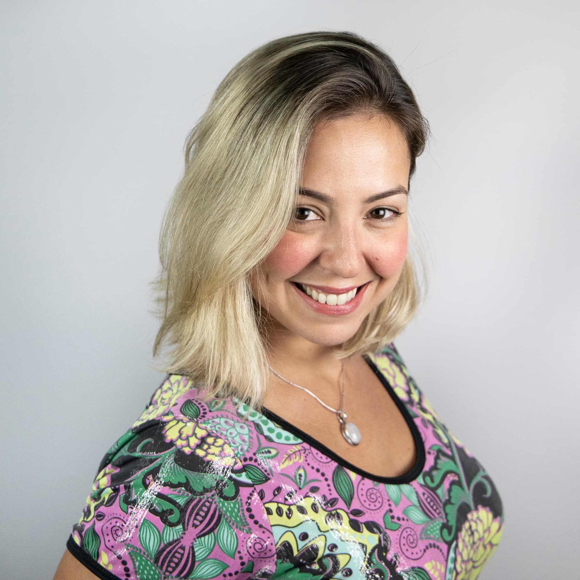 Carolina smiles at the camera, she is wearing a patterned top. Carolina smiles at the camera, she is wearing a patterned top.