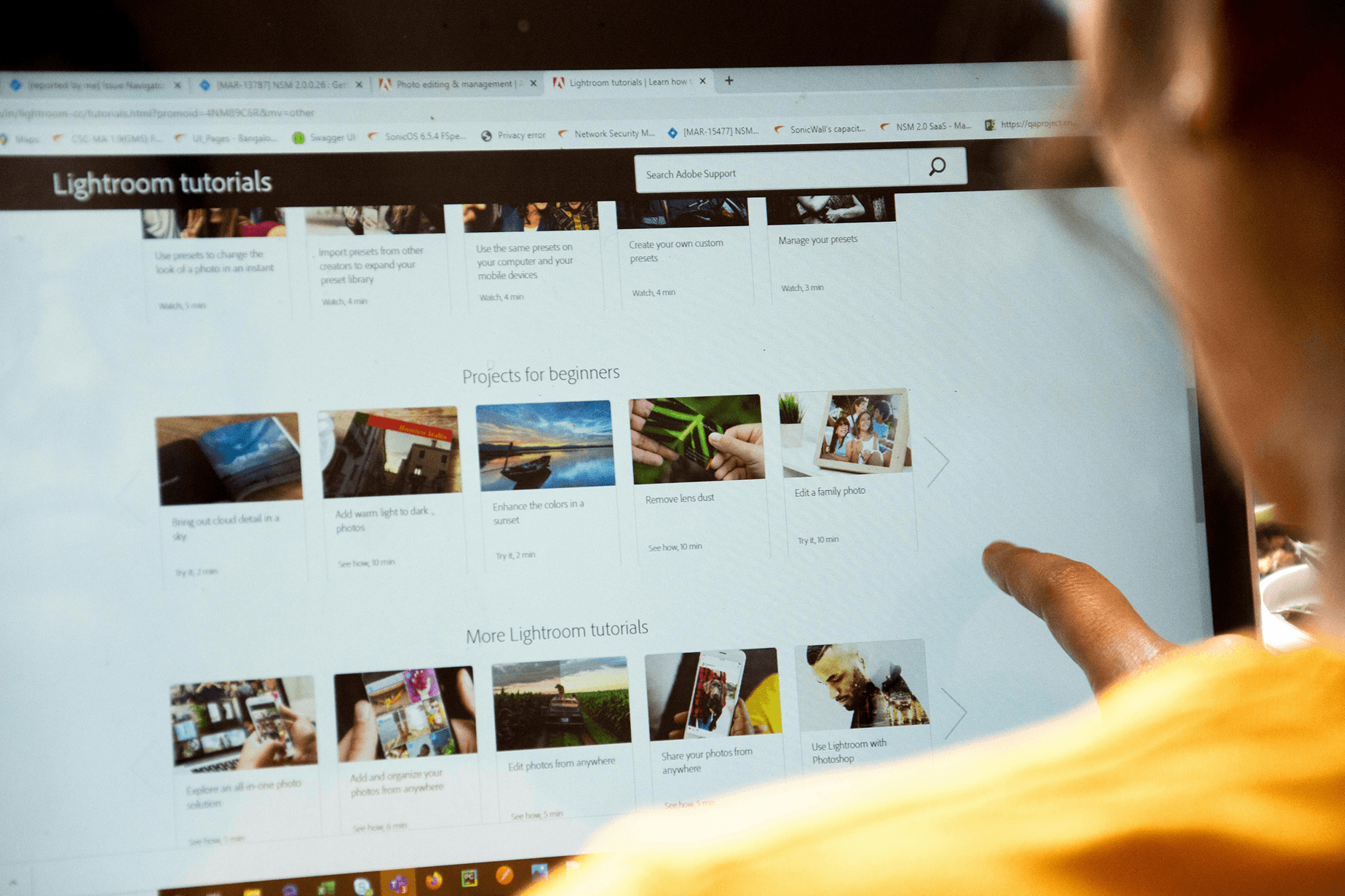 An over shoulder photo of someone looking at a Lightroom website full of tutorials An over shoulder photo of someone looking at a Lightroom website full of tutorials