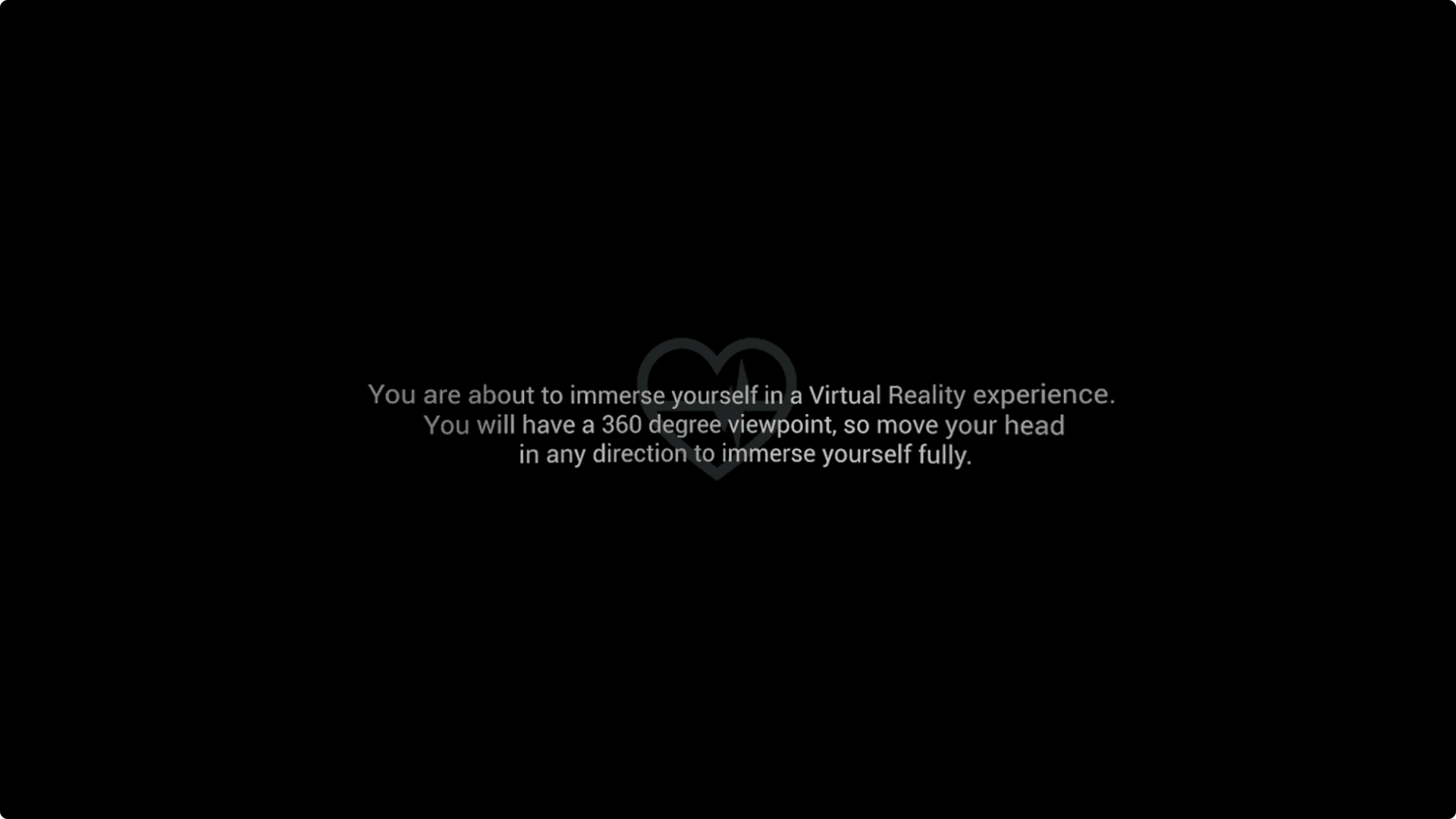 A black screen with the outline of a small, grey heart symbol in the middle, with text overlaying it that explains the user is about to enter a VR experience. A black screen with the outline of a small, grey heart symbol in the middle, with text overlaying it that explains the user is about to enter a VR experience.