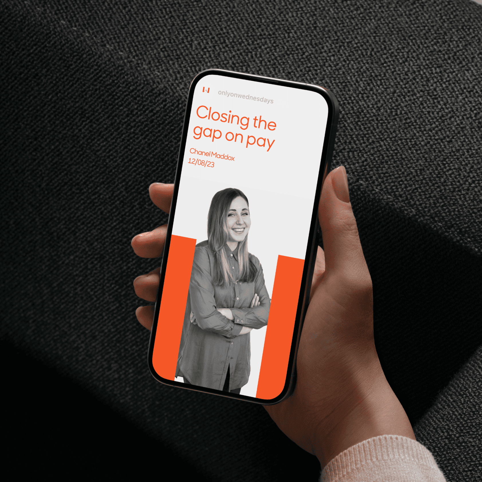 A hand holding a smartphone with the Only on Wednesdays branding on the screen A hand holding a smartphone with the Only on Wednesdays branding on the screen