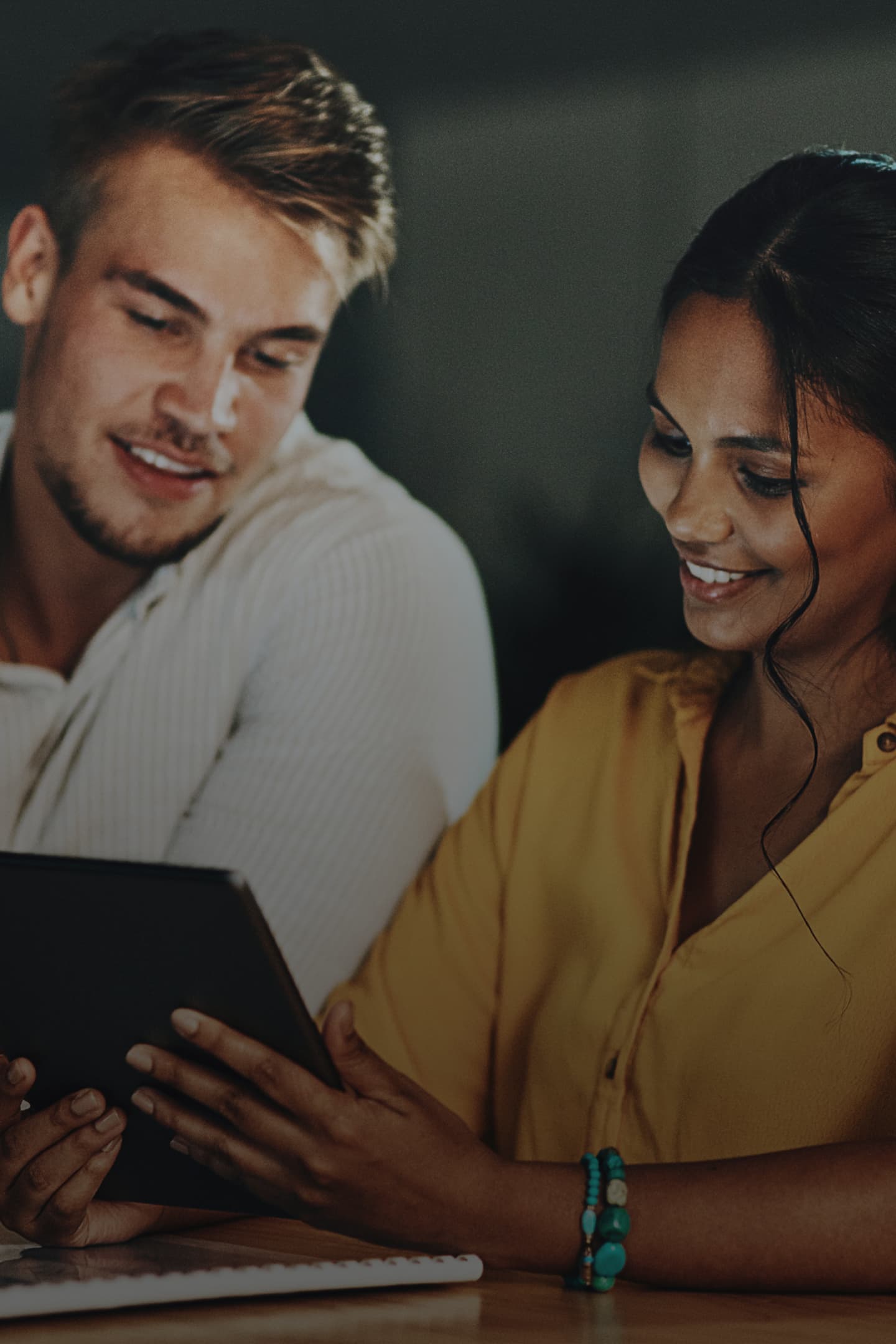 Image of a male and female using a laptop at night Image of a male and female using a laptop at night