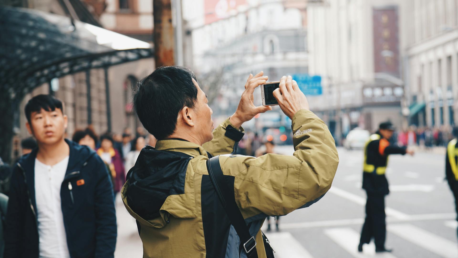 A man taking a photo in a street in China.